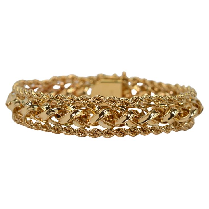 A perfect choice when looking for the bold look of gold but in a modest width. Multi-dimensional, with an interesting braided design, the highly polished 14 karat yellow gold is trimmed with accenting 14 karat yellow gold roping to create this desirable bracelet. At a moderate 1/2 inch width, this substantial gold statement piece is sized to fit most and presents beautifully when worn independently or combined with other pieces in your jewelry wardrobe. Of quality construction, the bracelet is f Luxury Yellow Gold Braided Bracelets For Formal Occasions, Luxury Yellow Gold Braided Bracelets For Women, Yellow Gold Diamond Cut Chain Bracelet, Classic Gold Braided Bracelet For Formal Occasions, Elegant Gold Braided Bracelet For Formal Occasions, Elegant Braided Bracelet Jewelry, Elegant Bracelets With Interwoven Design As Gift, Elegant Bracelets With Interwoven Design For Gift, Elegant Yellow Gold Jewelry With Interwoven Design