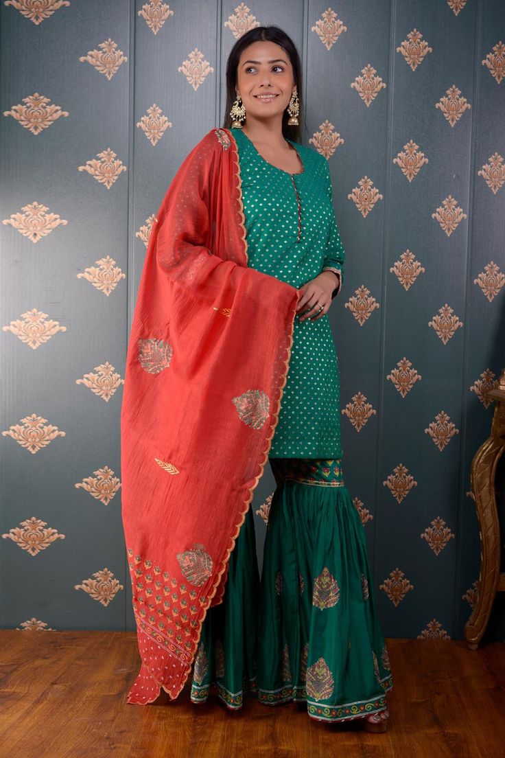 Green kurta with foil print motifs and lace trim on the sleeve hems. Comes with sharara and red chanderi dupatta.
Component: 3
Pattern: Print
Type Of Work: Foil Print
Neckline: Round
Sleeve Type: Three Quarter
Fabric: Kurta: Banarasi Chanderi, Sharara: Cotton Satin and Dupatta: Chanderi
Color: Green
Other Details: 
Printed dupatta with scalloped border
Side slits
Potli button front detailing
Occasion: Wedding - Aza Fashions Semi-stitched Slub Silk Sets With Dori Work, Semi-stitched Banarasi Silk Sharara With Dabka Work, Unstitched Sharara With Dabka Work For Festive Occasions, Semi-stitched Festive Sharara, Diwali Chinon Sharara With Dabka Work, Traditional Sharara With Gota Work For Eid, Unstitched Chinon Sharara For Navratri, Festive Sharara With Dabka Work And Kundan Material, Sharara With Gota Work For Eid