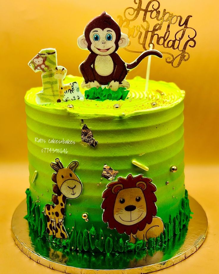 a green cake with a monkey and giraffe on it