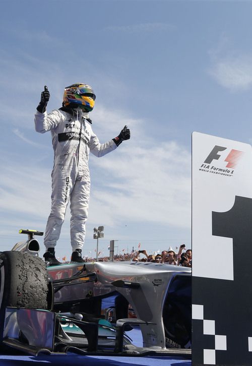 a man standing on top of a race car