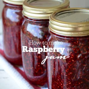 three jars filled with raspberry jam sitting on top of a table