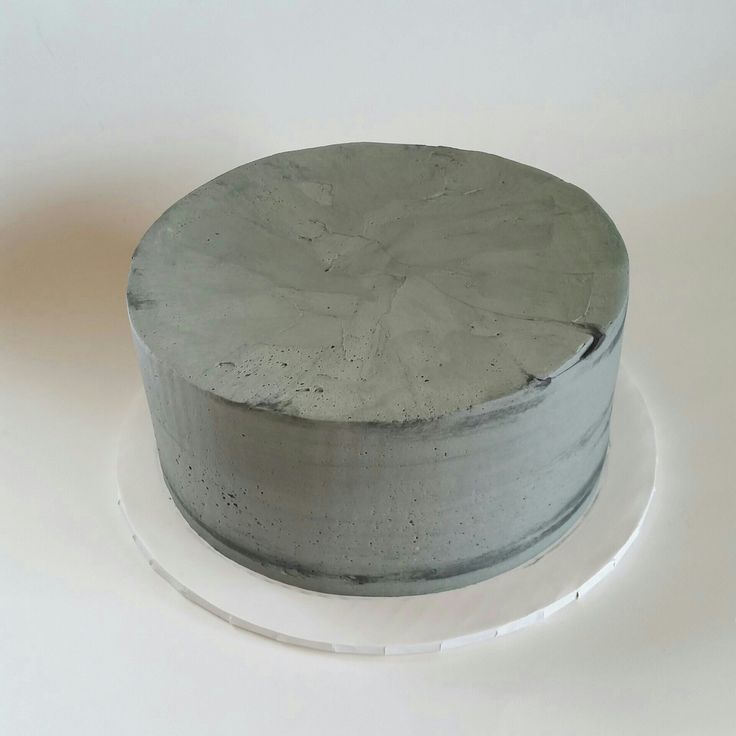 a white plate topped with a gray cake