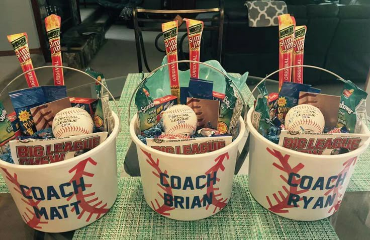 three buckets filled with baseball items sitting on top of a table