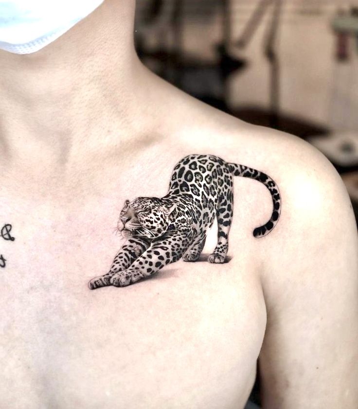 a woman's chest with a tattoo of a leopard on the left side of her body