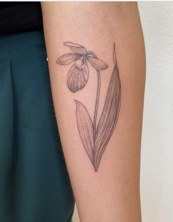 a woman's arm with a tattoo on it that has a flower in the middle