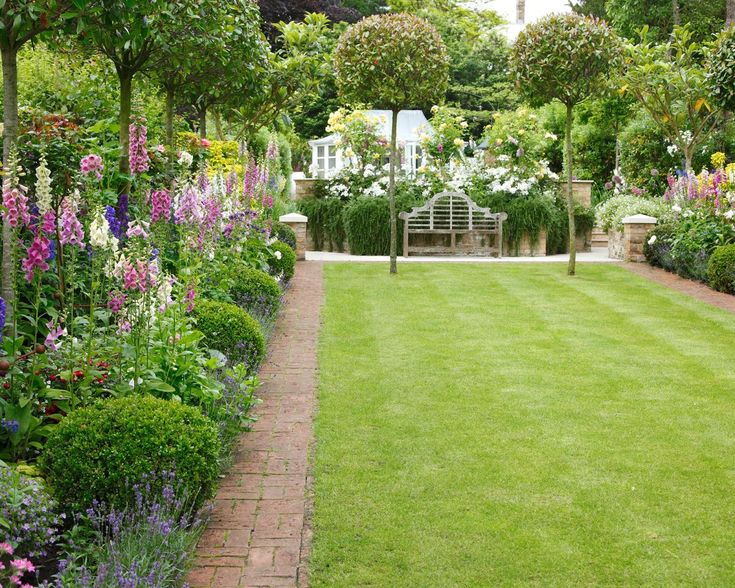 a lush green lawn surrounded by flowers and trees