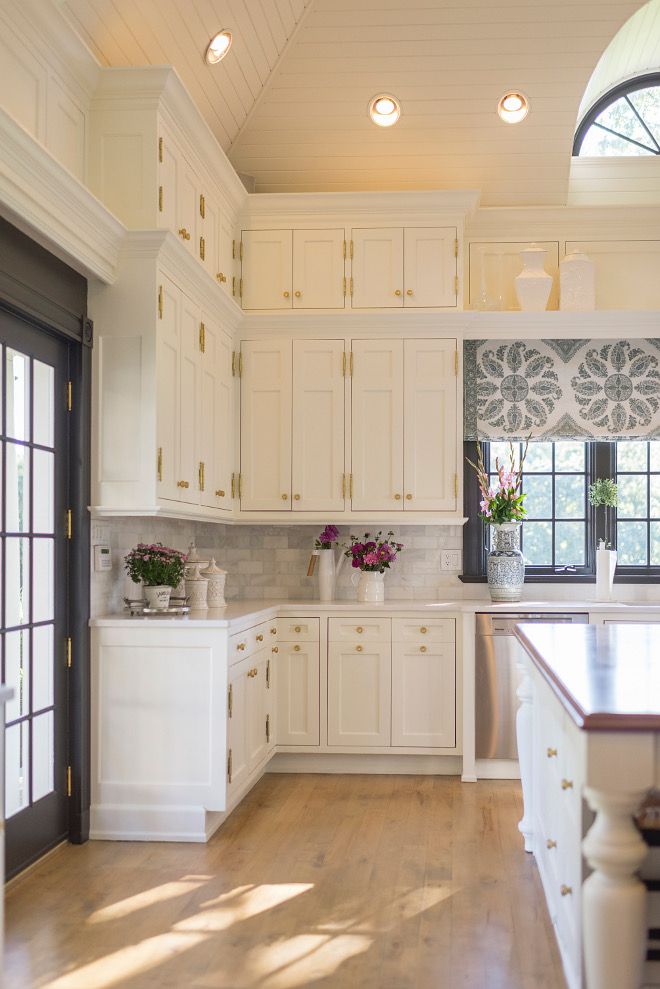 an instagram photo of a kitchen with white cabinets and wood flooring on the phone