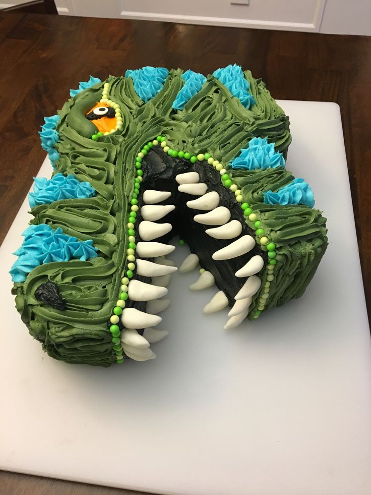 a cake shaped like a monster's mouth on top of a white cutting board