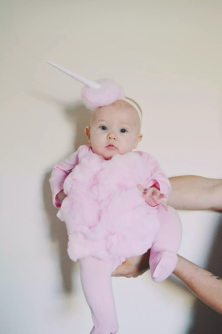 a person holding a baby in a pink dress