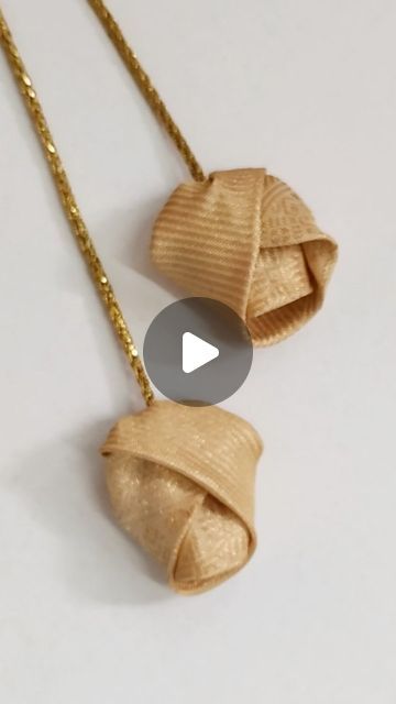 the necklace is made out of wood and has two pieces of gold chain attached to it