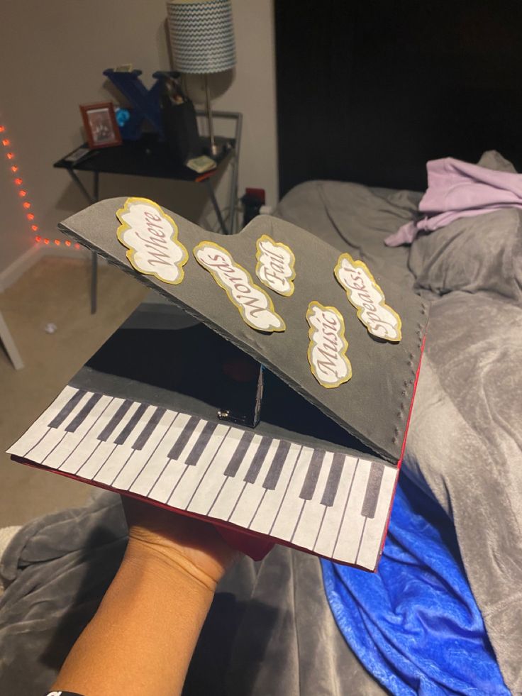 someone is holding up an open book with stickers on it and playing the piano