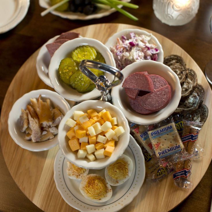 a wooden table topped with plates and bowls filled with different types of food on top of it