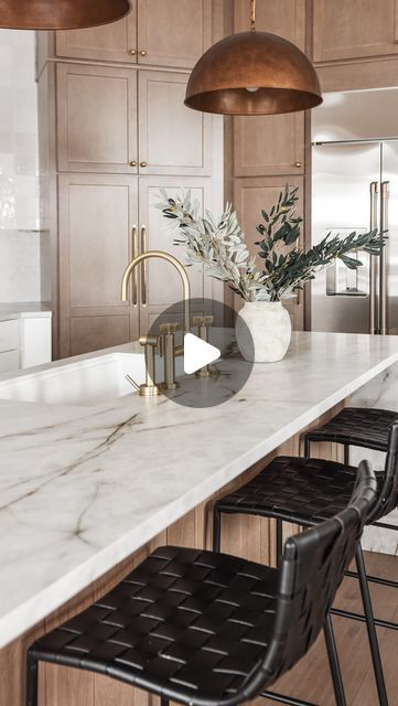 a kitchen with marble counter tops and bar stools