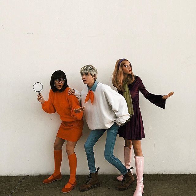 three women standing next to each other with one holding a magnifying glass in her hand