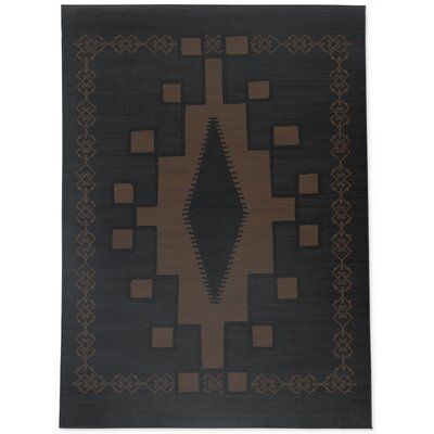 an area rug with brown and black designs on it, in the shape of a rectangle