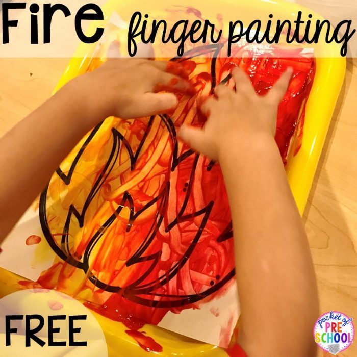 a child's hands painting with watercolors on a yellow tray that says fire finger painting