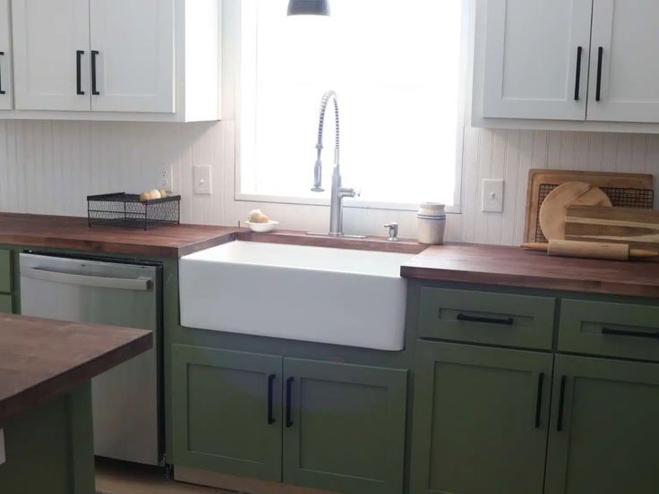 a kitchen with green cabinets and wooden counter tops is pictured in this image from the front view