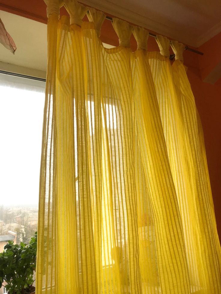 yellow sheer curtains hanging in front of a window