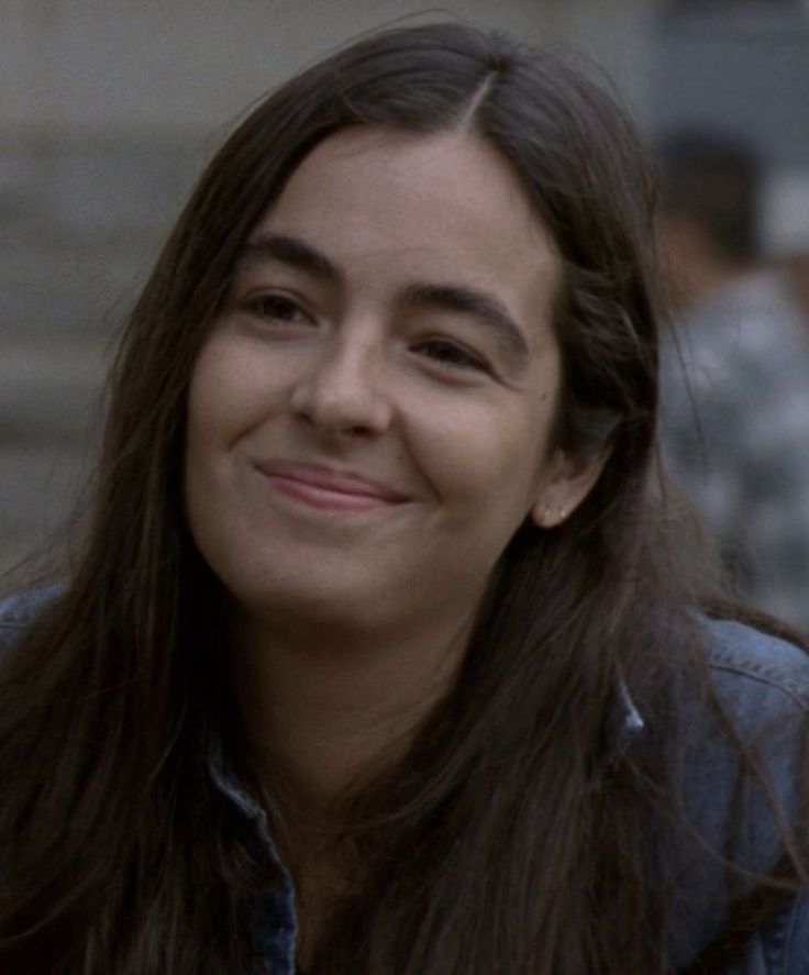 a woman with long hair smiling at the camera