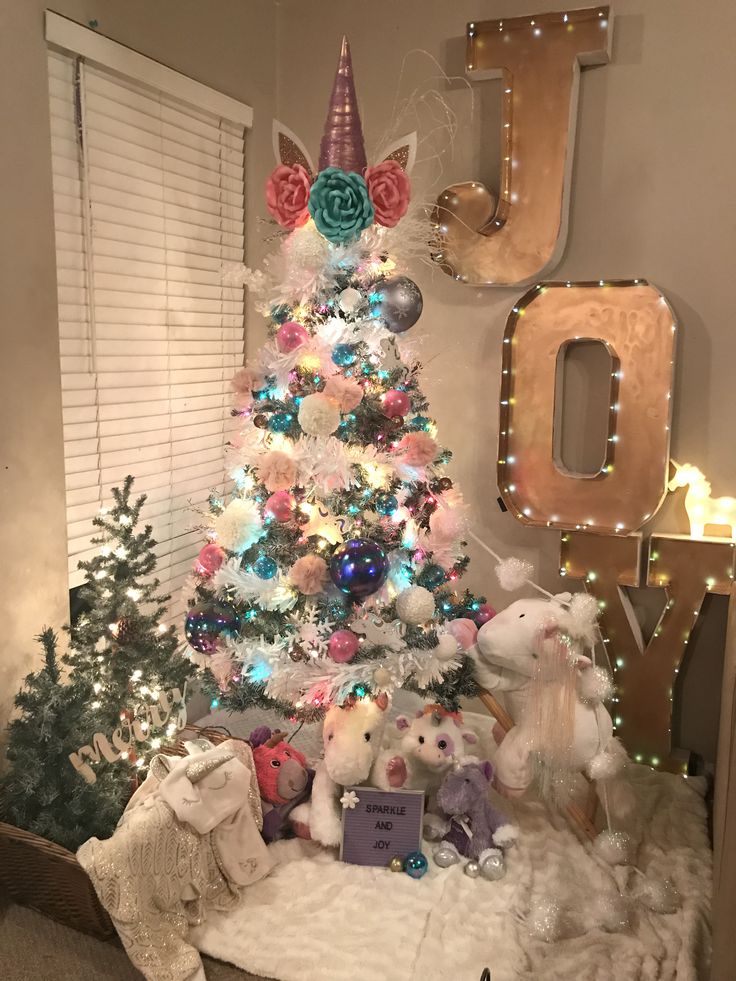 a decorated christmas tree in the corner of a room with lights and decorations on it