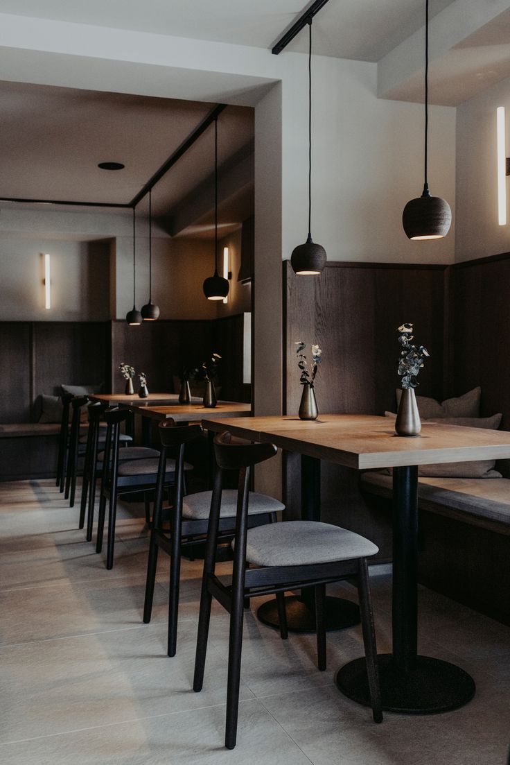 a long table with chairs and vases on it in a dining room next to couches