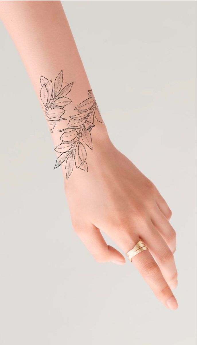 a woman's hand with a flower tattoo on her left arm and the wrist