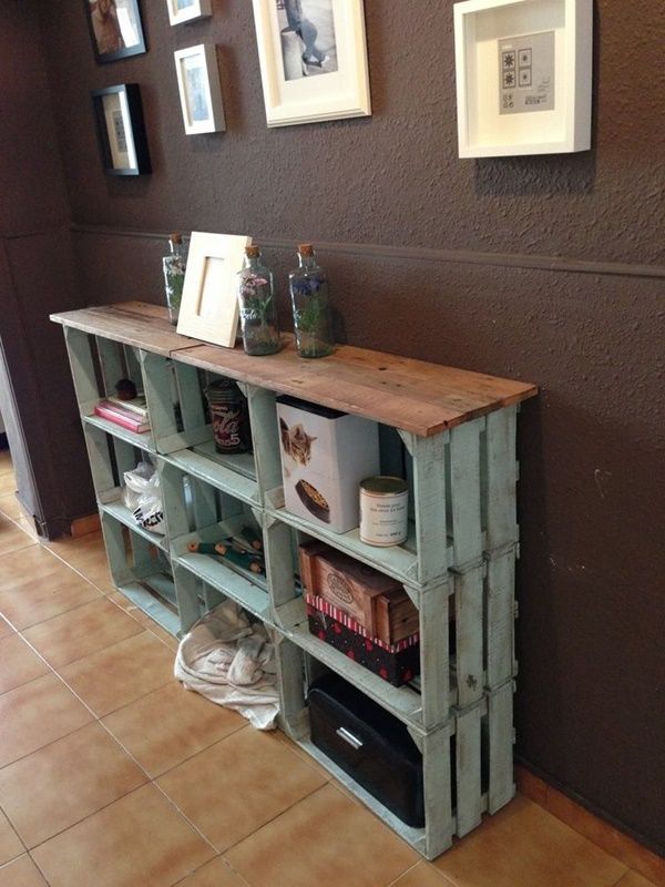 a shelf made out of pallets with pictures on the wall