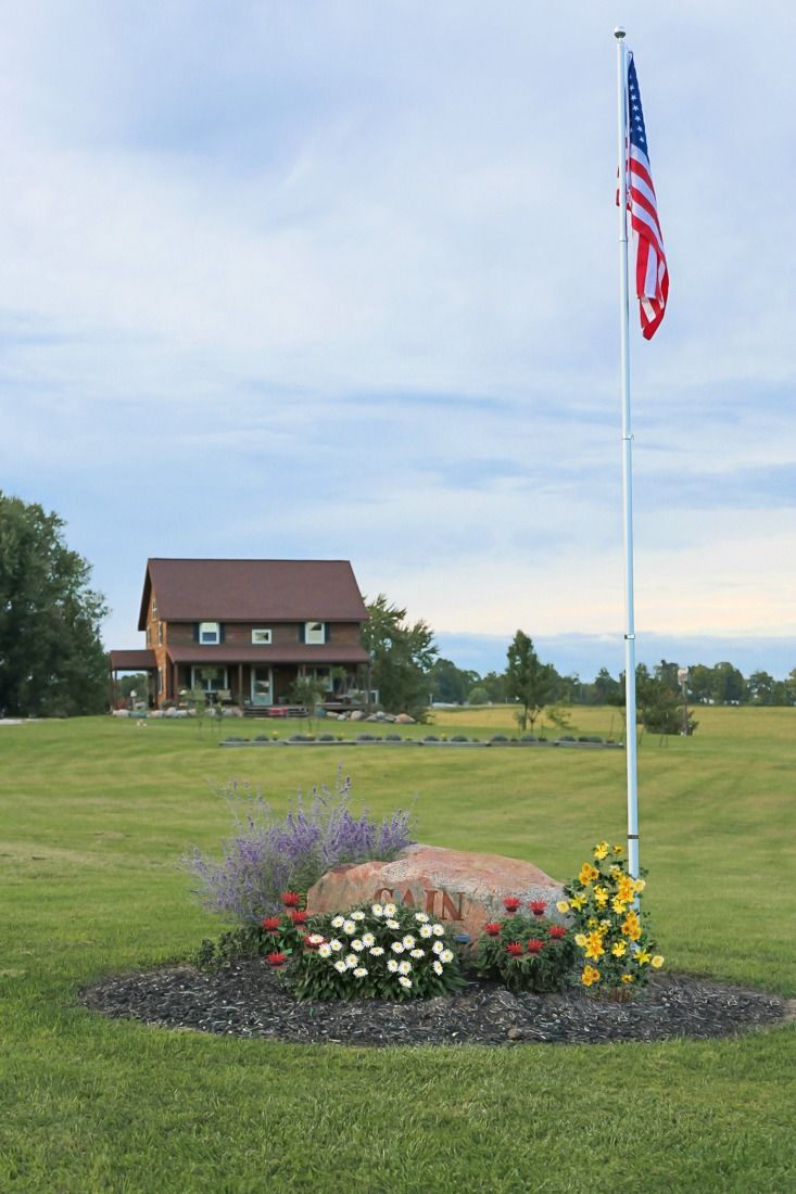 a flag pole in the middle of a flower bed