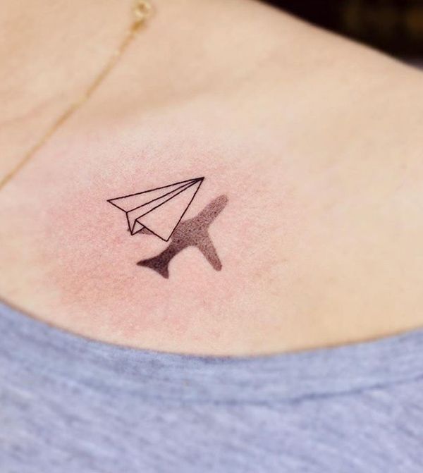 a woman with a small tattoo on her back shoulder that has an origami bird flying out of it