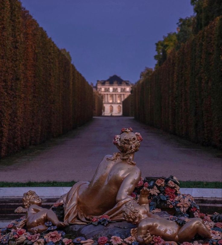 a golden statue sitting on top of a lush green field