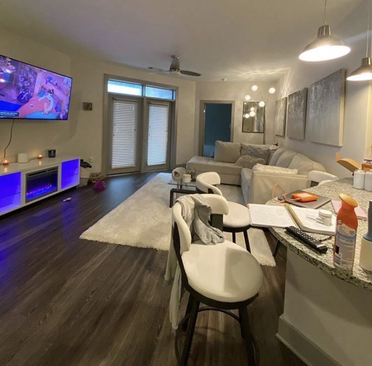 a living room filled with furniture and a flat screen tv mounted to the side of a wall