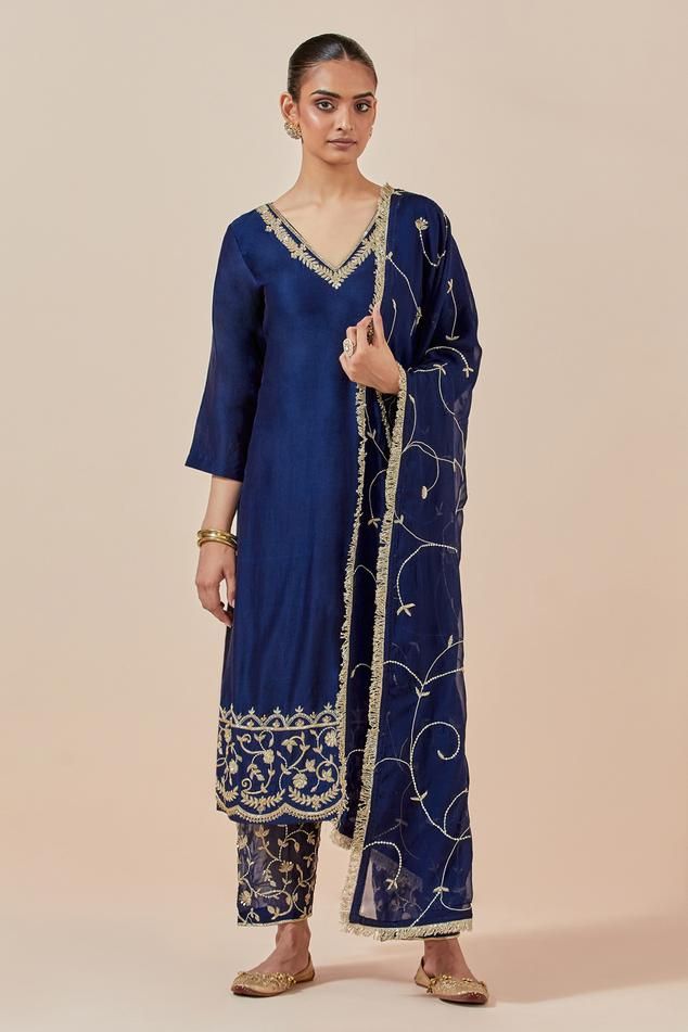 Blue straight kurta in chanderi silk base with floral embroidered hem. Comes with embroidered hem pant and tissue organza dupatta.
Components: 3
Pattern: Embroidered
Type Of Work: Floral Pattern
Neckline: V-Neck
Sleeve Type: Straight Three Quarter
Fabric: Chanderi Silk, Tissue Organza
Color: Blue
Other Details: 
Attached lining
Embroidered hem pant
Elasticated back waistband
Length:
Kurta: 47 inches
Pant: 37 inches
Approx. product weight (in kgs): 1.5
Occasion: Wedding - Aza Fashions V Neck Kurta, Embroidered Hem, Kurta Set For Women, Straight Kurta, How To Hem Pants, Organza Dupatta, Fashion App, Boutique Design, Kurta Set