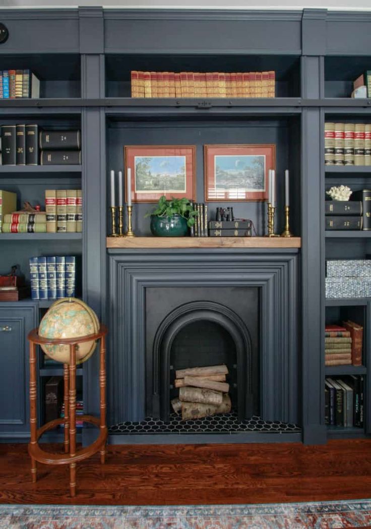 a living room filled with furniture and a fire place next to a book shelf covered in books