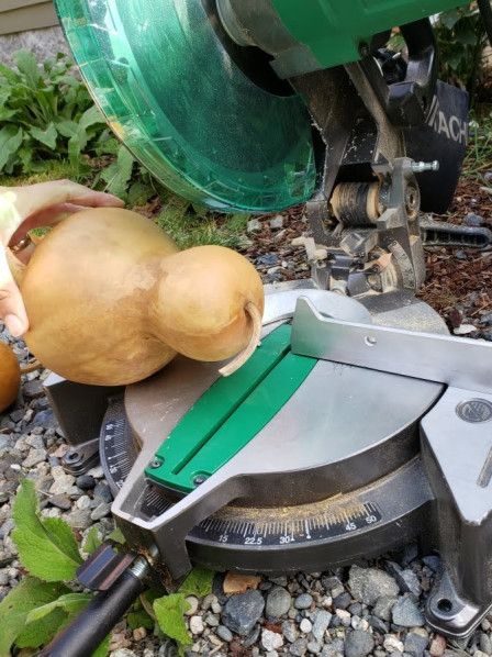 a potato being cut into pieces on top of a leafy green object next to a lawn mower