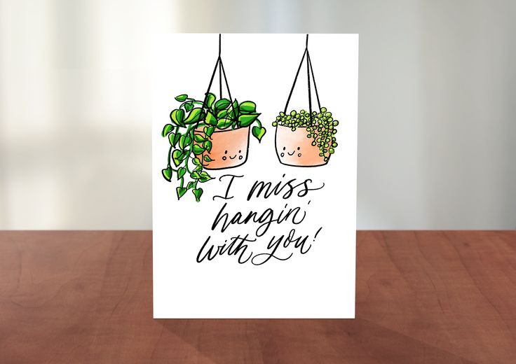 a card with two potted plants hanging from it's sides on a table