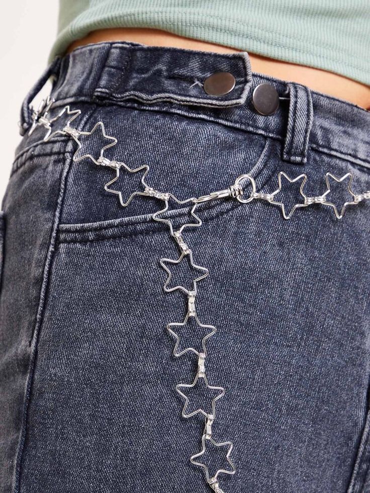 the back of a woman's jeans with silver stars on it and a chain attached to her waist