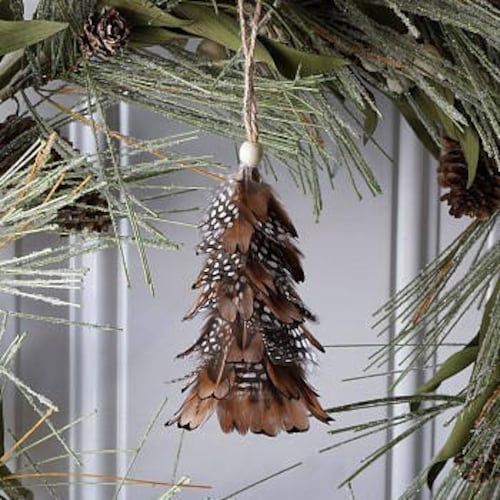 a pine cone ornament hanging from a christmas tree