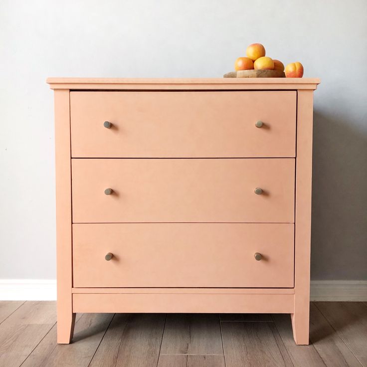 a pink dresser with apples on top of it