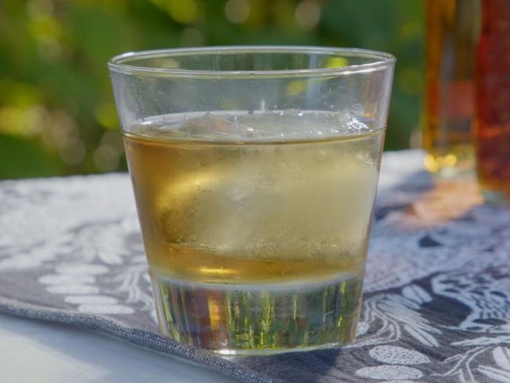 a glass filled with liquid sitting on top of a table