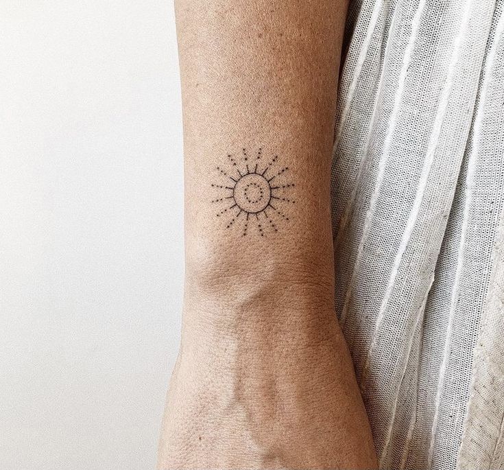 a person's arm with a small tattoo on the left side of their arm