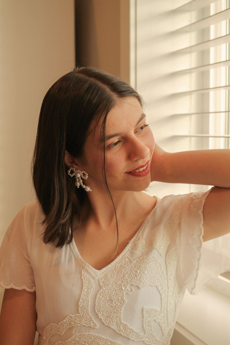 Is your jaw on the floor?! Well, me too... Meet the Melody Bow Earring in Pearl. She is a completely beaded earring, made with artificial pearls, and a sterling silver ear post. Its completey hypoallergenic and nickel free (like always!) and it is INSANELY lightweight. We all know that bows and pearls are both super on trend right now, so these earrings are honestly the perfect finishing piece to any outfit. They just feel like the perfect blend of a statement a dainty piece. This earring measur Formal Pearl Earrings With Bow Detail, Bow Pearl Earrings, Silver Dangle Earrings With Bow, Gold Pearl Earrings With Bow For Gift, Elegant Bow Pearl Earrings, Bows And Pearls, Bow Earring, Post Its, Pearl Rose