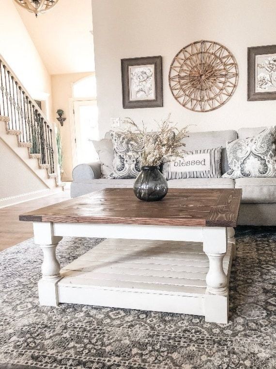 a living room with couches, coffee table and stairs in the backround