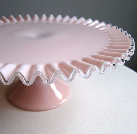 a pink cake plate sitting on top of a table