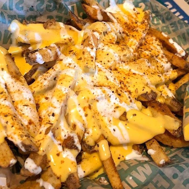 a basket filled with french fries covered in cheese