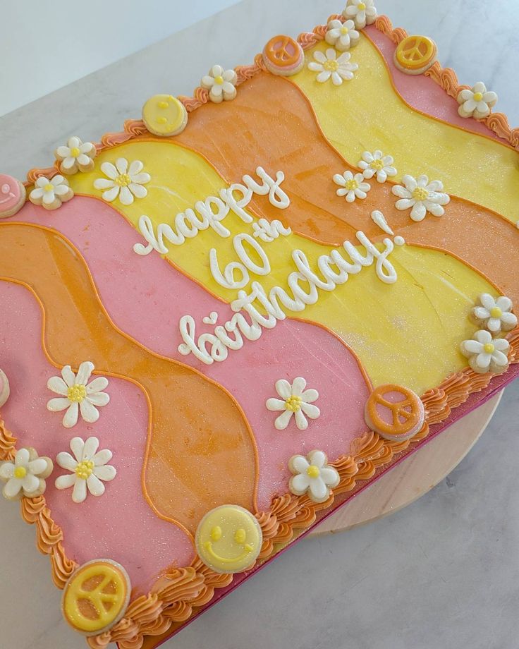 a birthday cake decorated with flowers and peace signs