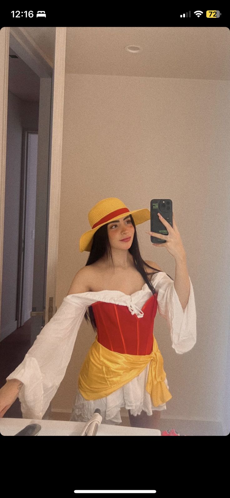 a woman wearing a yellow and red outfit taking a selfie in front of a mirror