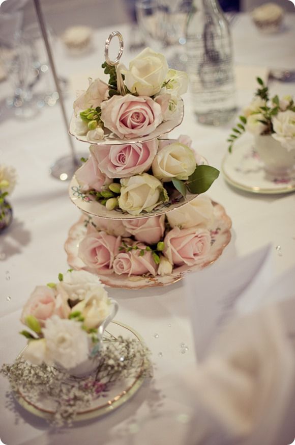 three tiered trays filled with flowers on top of a table