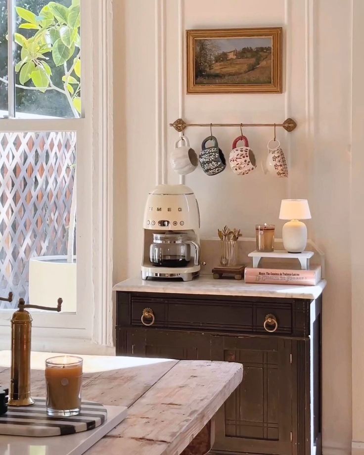 a kitchen counter with a coffee maker on top of it next to an open window