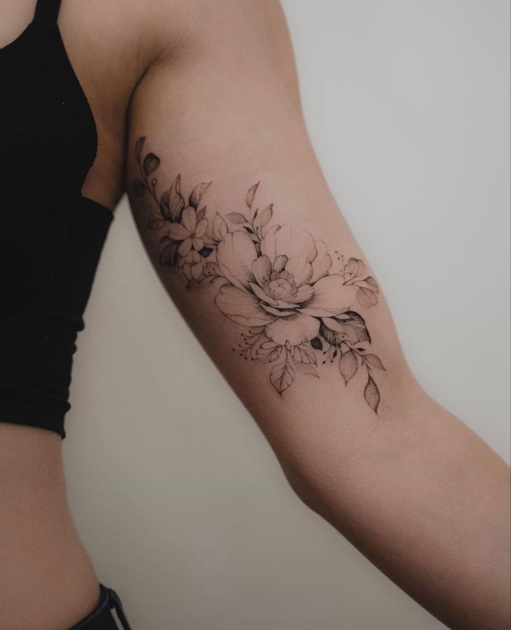 a woman's arm with a flower tattoo on the left side of her body