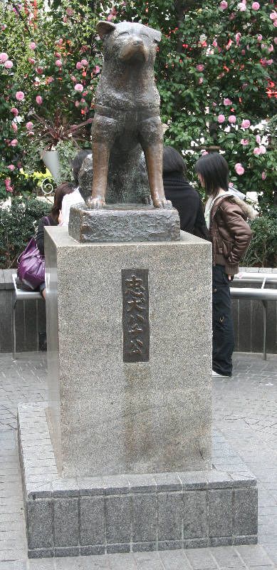 a statue of a dog sitting on top of a stone block